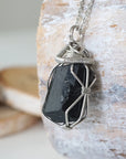 Left angle detail of raw black tourmaline necklace for men – close-up of wire wrapping and deep black tourmaline.