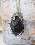 Back angle view of raw black tourmaline necklace for men – showcases wire wrapping and natural stone matrix.