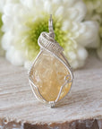 Front view of wire wrapped citrine pendant showing sterling silver wire wrapping detail and natural raw crystal