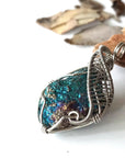 Left angle close-up of peacock ore pendant for women – highlighting unique wire-wrapped artistry, white gold copper, Capricorn and Cancer birthstone.