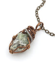 Necklace with a green stone pendant on a white background