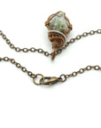 Necklace with a copper wire-wrapped pendant on a white background