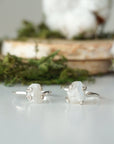Two adjustable raw rainbow moonstone rings showing natural variation in stone size, shape, and moonstone flash in sterling silver settings.