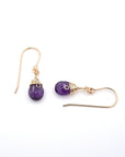Closeup showing details of amethyst drop earrings, faceted amethyst stone, 14k gold filled setting