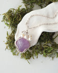 Handmade silver wire wrapped amethyst and freshwater pearl necklace laying flat on a silver plated chain, artisan jewelry for women