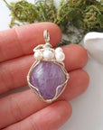 Amethyst and freshwater pearl pendant necklace in hand for size reference, silver wire wrapped, handcrafted gemstone jewelry