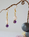 Side view of gold plated copper wire wrapped drop earrings featuring 6mm amethyst bead and 6mm rose quartz bead