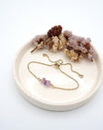 Handmade amethyst bracelet displayed on ceramic tray showing natural purple crystals and gold chain - February birthstone gift for her