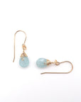 Close-up of 14k gold filled aquamarine drop earrings, focusing on faceted gemstone and artisan wire wrapping