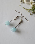 Aquamarine drop earrings laying flat, showing all details and earring hook, antique bronze finish