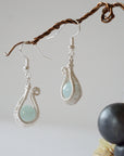 Another angle of aquamarine drop earrings highlighting detailed wire artistry and genuine aquamarine bead