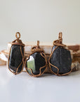 Three raw black tourmaline pendants showing natural stone variation in size and shape, artisan jewelry by Designs by Nature Gems.