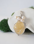 Side angle of handmade citrine and freshwater pearl pendant necklace, silver wire wrapped jewelry