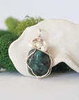 Detailed front view of silver wire wrapped emerald and freshwater pearl pendant, unique artisan necklace