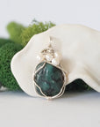 Detailed front view of silver wire wrapped emerald and freshwater pearl pendant, unique artisan necklace