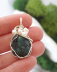 Emerald and freshwater pearl pendant necklace in hand for size reference, silver wire wrapped, handcrafted gemstone jewelry