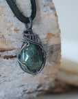 Right angle detail of emerald necklace for men with natural polished-raw emerald and handcrafted antiqued sterling silver wrapping