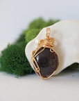 Back angle detail of garnet and freshwater pearl pendant, showing wire wrapping and natural stone