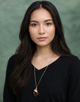 Garnet and freshwater pearl pendant on gold plated brass chain on a model.