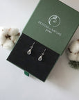 Herkimer diamond sterling silver drop earrings in branded Designs by Nature Gems jewelry box, showcasing handcrafted faceted Herkimer diamond and sterling silver wire wrapping