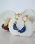 Side angle view of Lapis Lazuli Moon Open Circle Stud Earrings hanging on jewelry display, minimalist 14k gold filled wire wrap, limited edition.