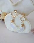 Side angle view of Rainbow Moonstone Moon Open Circle Stud Earrings hanging on jewelry display, minimalist 14k gold filled wire wrap, limited edition.