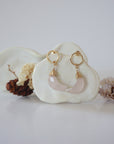 Front angle look at Lux Rose Quartz Moon Open Circle Stud Earrings on jewelry display, faceted natural rose quartz, gold filled, handmade.