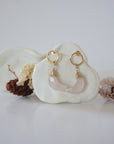 Front angle look at Lux Rose Quartz Moon Open Circle Stud Earrings on jewelry display, faceted natural rose quartz, gold filled, handmade.