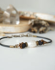 Close-up view of a men’s pearl leather bracelet featuring a natural freshwater pearl and lava stone beads
