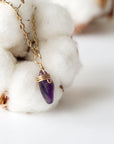 Right side angle of minimalist amethyst necklace, raw amethyst pendant wire wrapped in gold plated copper