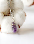 Right side angle of minimalist amethyst necklace, raw amethyst pendant wire wrapped in silver plated copper