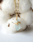 Back side angle of minimalist aquamarine necklace, showing simple wire wrapping and gold plated chain