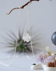 Close-up front view of minimalist rainbow moonstone necklace for women, natural raw moonstone in 925 sterling silver prong setting (June birthstone).
