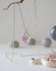 Back view of sterling silver claw setting holding natural raw amethyst stone on minimalist February birthstone necklace