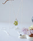 Back view of minimalist raw peridot pendant — 925 sterling silver four-prong setting and bail detail, handcrafted dainty crystal necklace for women, August birthstone jewelry