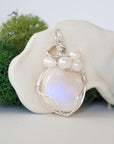 Side angle of handmade moonstone and freshwater pearl pendant necklace, silver wire wrapped jewelry