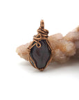 Back angle of raw garnet pendant showing wire wrapping and natural crystal texture