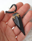 Black obsidian arrowhead necklace for men with gold plated copper wire wrap, shown in hand for size reference, by Designs by Nature Gems.