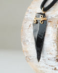 Side angle detail of men’s black obsidian arrowhead necklace, gold plated copper wire wrap, on black leather cord by Designs by Nature Gems.