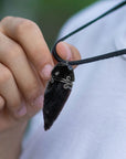 Men’s black obsidian arrowhead necklace on male model, artisan wire wrapped pendant, handcrafted by Designs by Nature Gems.