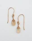 Detailed front view of opal drop earrings, natural faceted opal with minimalist 14k gold filled wire wrapping, Designs by Nature Gems