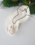 Handmade silver wire wrapped opal and freshwater pearl necklace laying flat on a silver plated chain, artisan jewelry for women