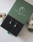 Opal sterling silver drop earrings in branded Designs by Nature Gems jewelry box, showcasing handcrafted faceted opal and sterling silver wire wrapping