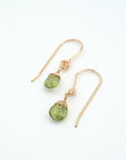 Angled look at peridot drop earrings, artisan wire wrapping in 14k gold filled, August birthstone