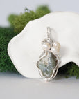 Detailed front view of silver wire wrapped peridot and freshwater pearl pendant, unique artisan necklace