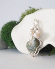 Side angle of handmade peridot and freshwater pearl pendant necklace, silver wire wrapped jewelry