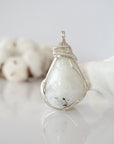 Front angle view of natural rainbow moonstone pendant with detailed artisan soft silver copper wire wrapping