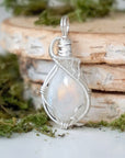 Front angle view of natural rainbow moonstone cabochon pendant with detailed 925 sterling silver wire wrapping