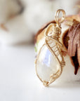 Left angle view of natural rainbow moonstone pendant highlighting artisan 14k gold filled wire wrapping
