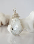 Right angle view of rainbow moonstone pendant showing handcrafted soft silver copper wire wrapping detail